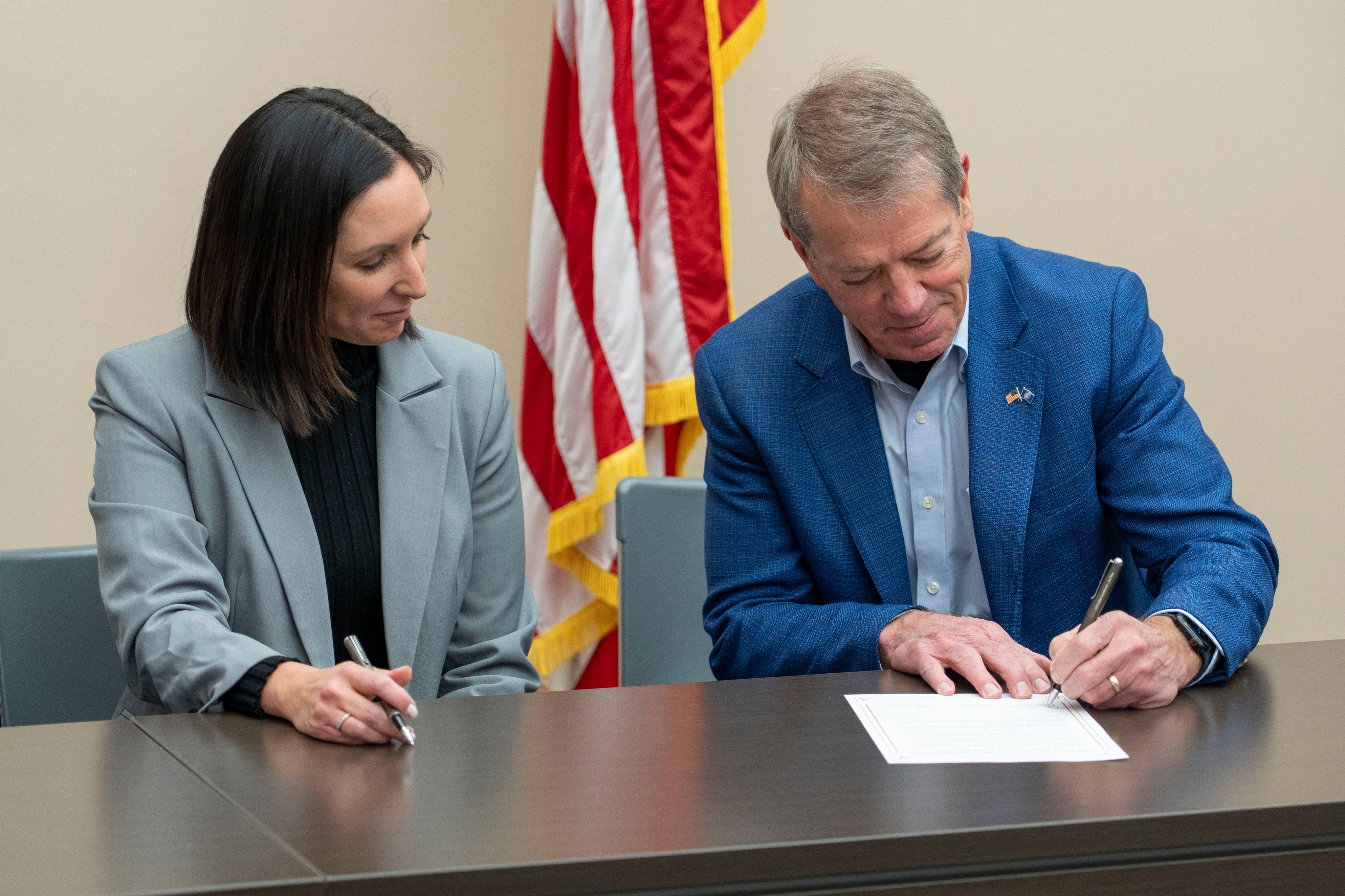 NDOT Director Vicki Kramer watches Governor Jim Pillen sign the order.