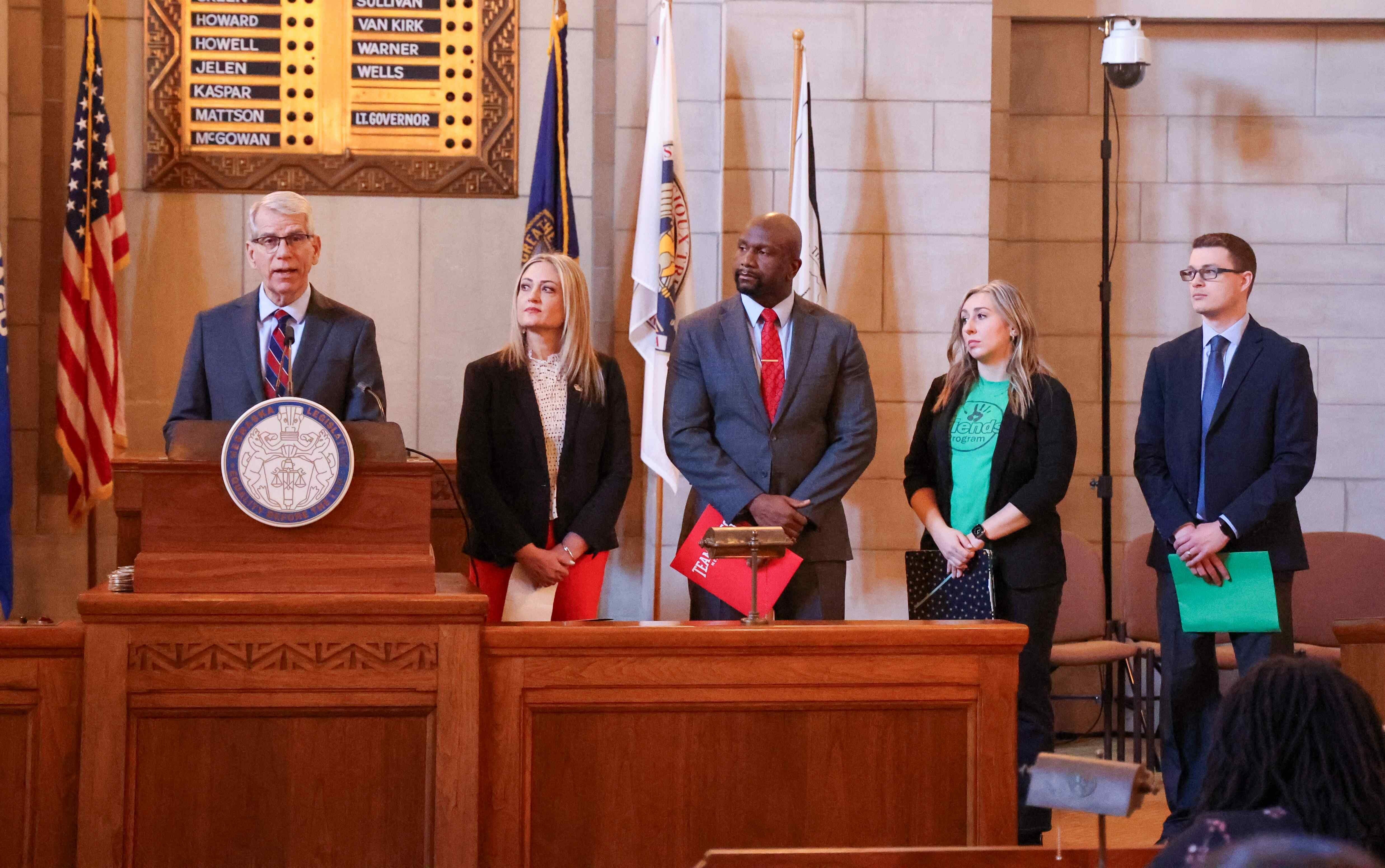 Lt. Governor Joe Kelly addresses the audience as Melissa Mayo, MENTOR Nebraska executive director, DeMoine Adams, CEO TeamMates, Jalin Gerdes, The Friends Program executive director, and Sean Davis, Nebraska  State Personnel Director look on.