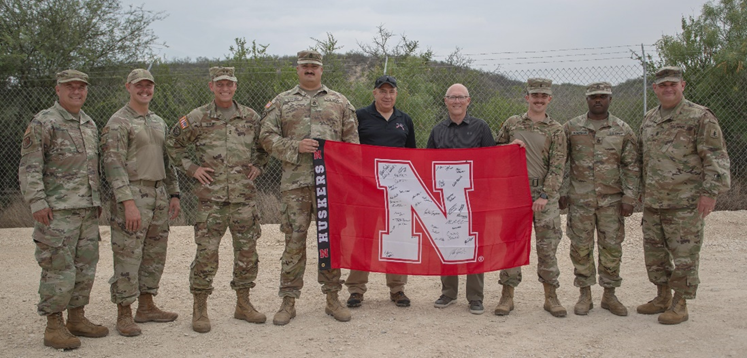 Senators Visit Deployed Troops Holding Husker Flag at Border
