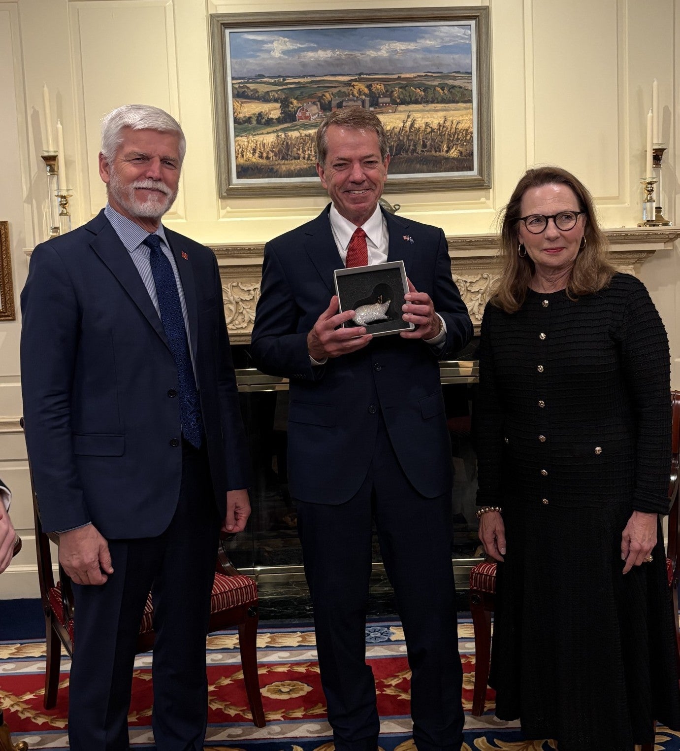 Gov. Jim Pillen displays a gift he received from President Petr Pavel, of the Czech Republic. He id flanked by the President to the left of the picture, and Gov. Pillen's wife, Suzanne Pillen to the right.