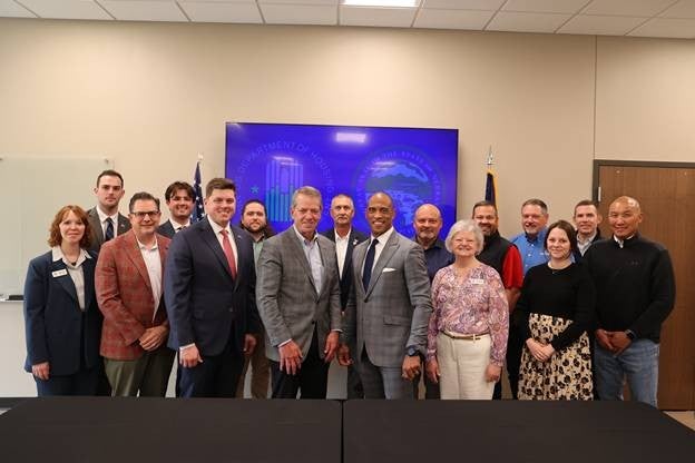 Governor Jim Pillen and HUD Secretary Scott Turner, front and center, are surrounded by local business leaders for a group photo at the Opportunity Zones and Workforce Housing Listening Session
