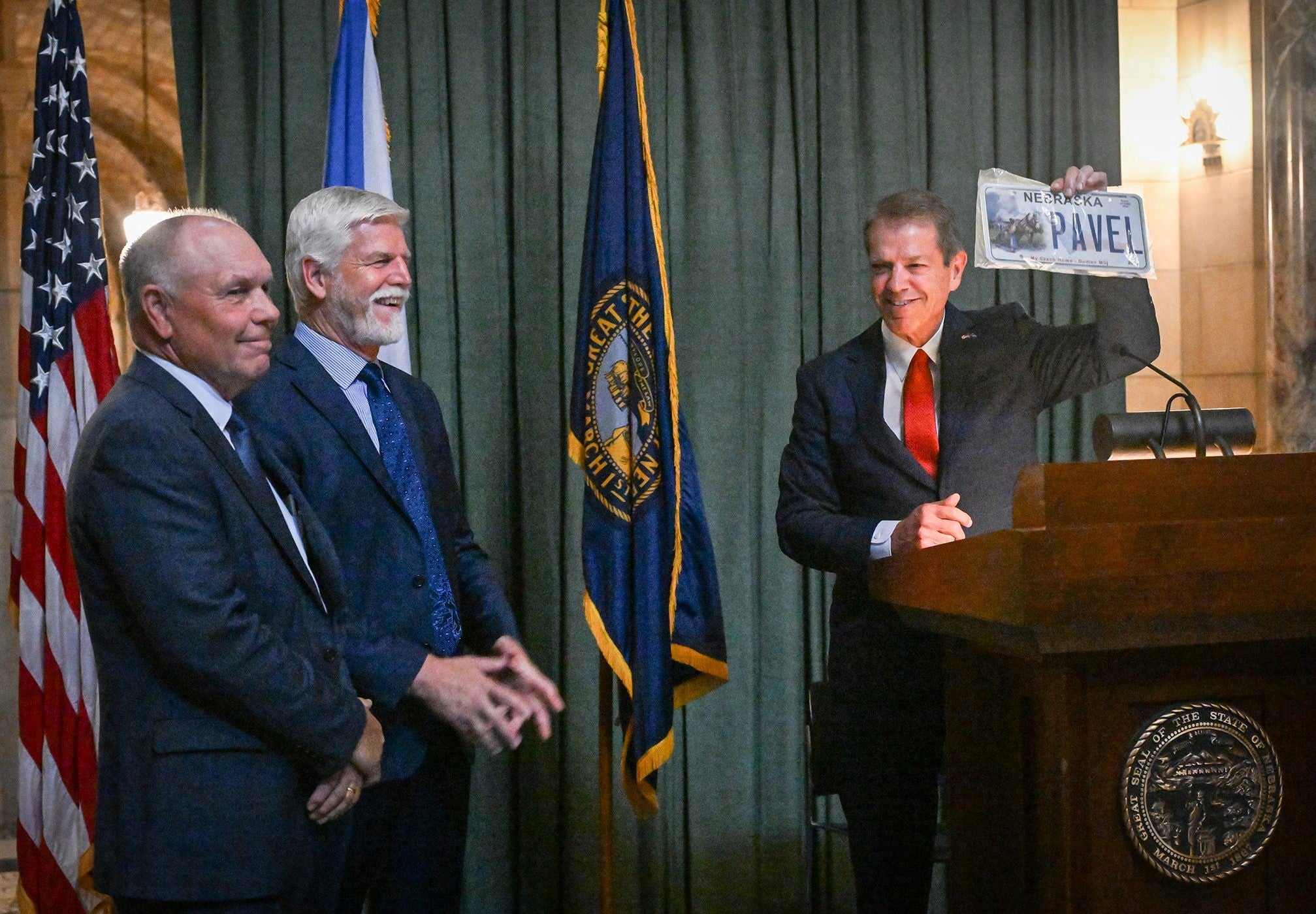 Gov. Pillen holds up personalized Nebraska license plate for President Pavel.