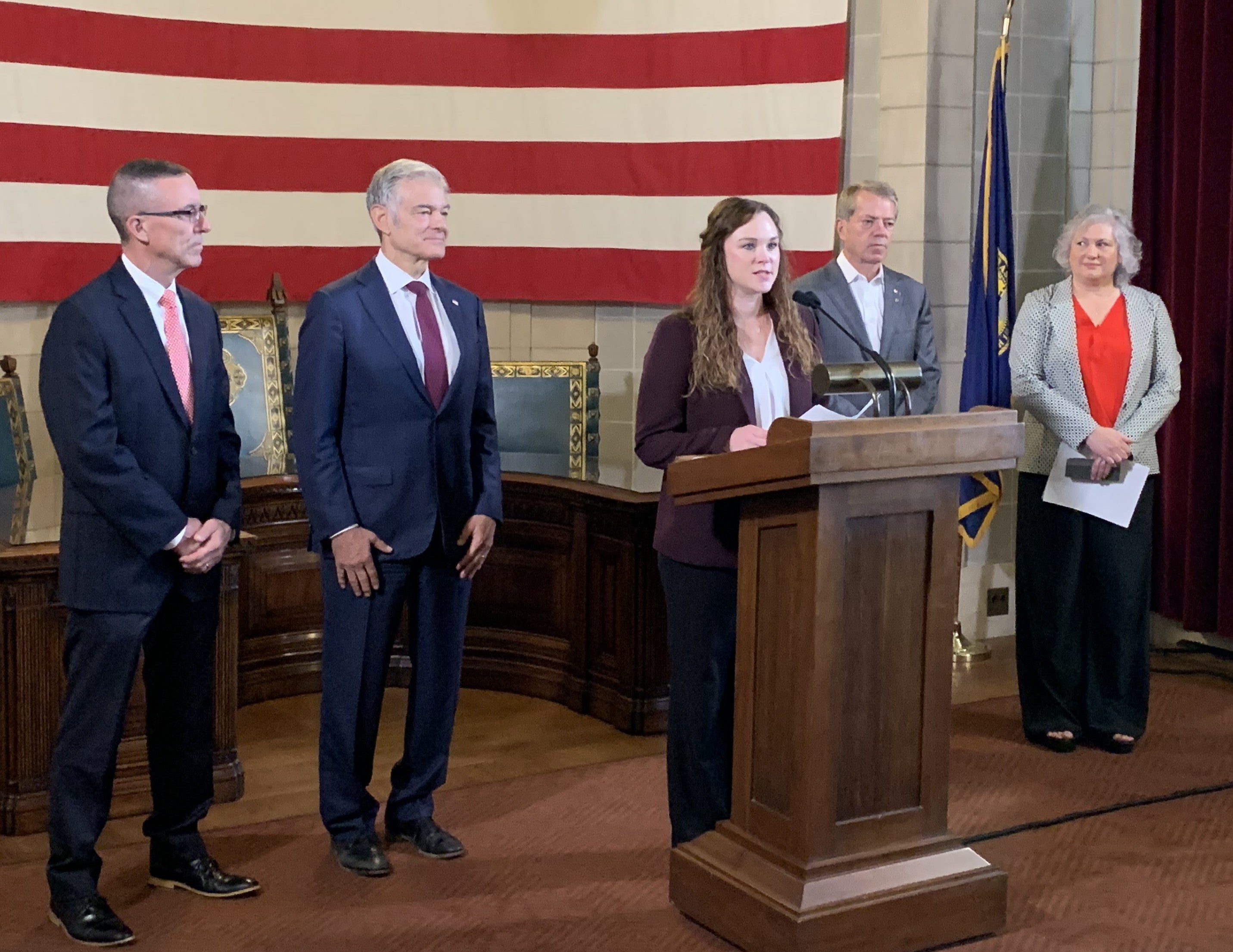 Ashley Newmyer speaks at news conference updating successful award of $177 million in RHTP funding. He is joined by Dave Randolph, Dr. Mehmet Oz, Gov. Pillen, and Laura McDougall.
