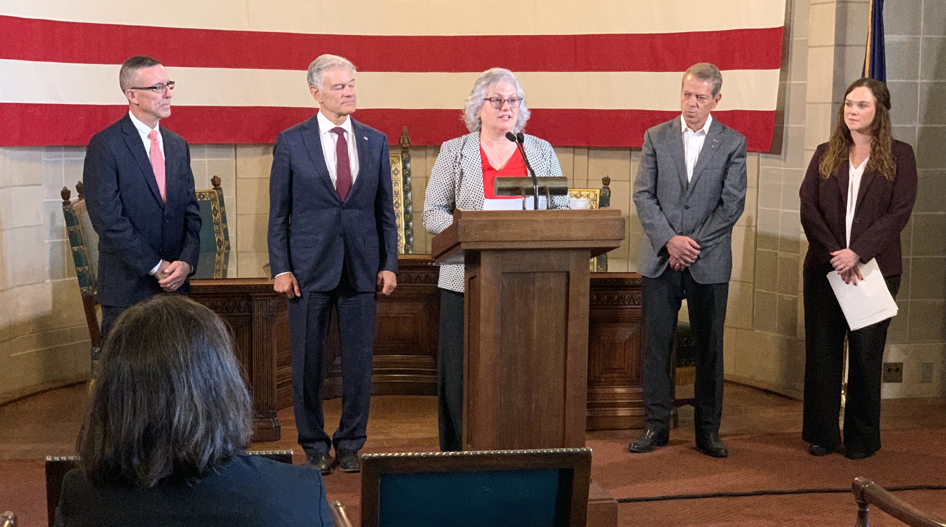 Laura McDougall speaks at news conference updating successful award of $177 million in RHTP funding. He is joined by Dave Randolph, Dr. Mehmet Oz, Gov. Pillen, and Ashley Newmyer.