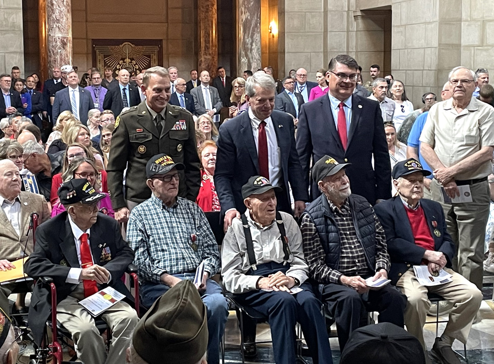 Nebraska National Guard Adjutant General Major General Craig Strong, Governor Jim Pillen, and Nebraska Department of Veterans’ Affairs (NDVA) Director John Hilgert pictured with WWII Veterans