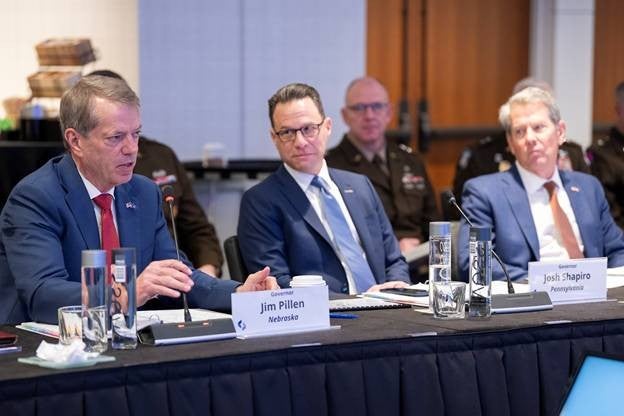 Governor Jim Pillen, Nebraska, and Governor Josh Shapiro, Pennsylvania, sitting in front of a table with other members of the Council of Governors.