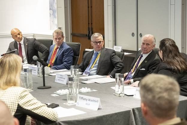 Governor Jim Pillen and other members of the Council of Governors sitting around a table discussing matters.