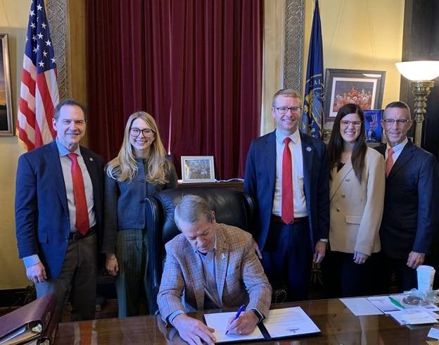 Governor Jim Pillen signs an executive order (EO) to preserve federal earned benefits for eligible youth in the care of the Department of Health and Human Services (DHHS). Gov. Pillen was joined at the signing event by Alex J. Adams, assistant secretary of ACF; Martha Verno, deputy assistant secretary for external affairs at ACF; Senator Brian Hardin, Health and Human Services committee chairman; Dr. Steve Corsi, CEO of DHHS, and Dr. Alyssa Bish, director of the Division of Children and Family Services.