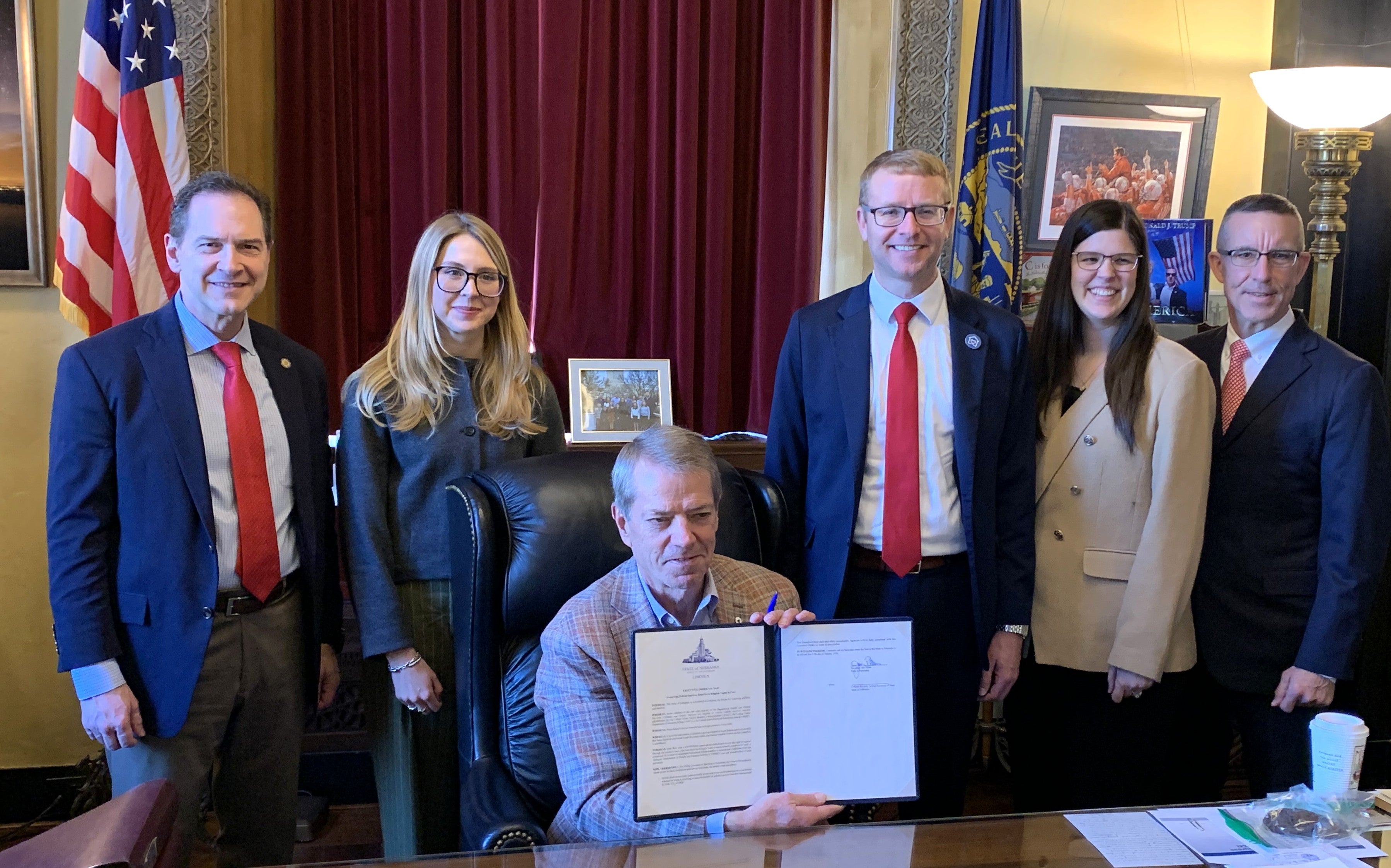 Governor Jim Pillen displays an executive order (EO) to preserve federal earned benefits for eligible youth in the care of the Department of Health and Human Services (DHHS). Gov. Pillen was joined at the signing event by Alex J. Adams, assistant secretary of ACF; Martha Verno, deputy assistant secretary for external affairs at ACF; Senator Brian Hardin, Health and Human Services committee chairman; Dr. Steve Corsi, CEO of DHHS, and Dr. Alyssa Bish, director of the Division of Children and Family Services.