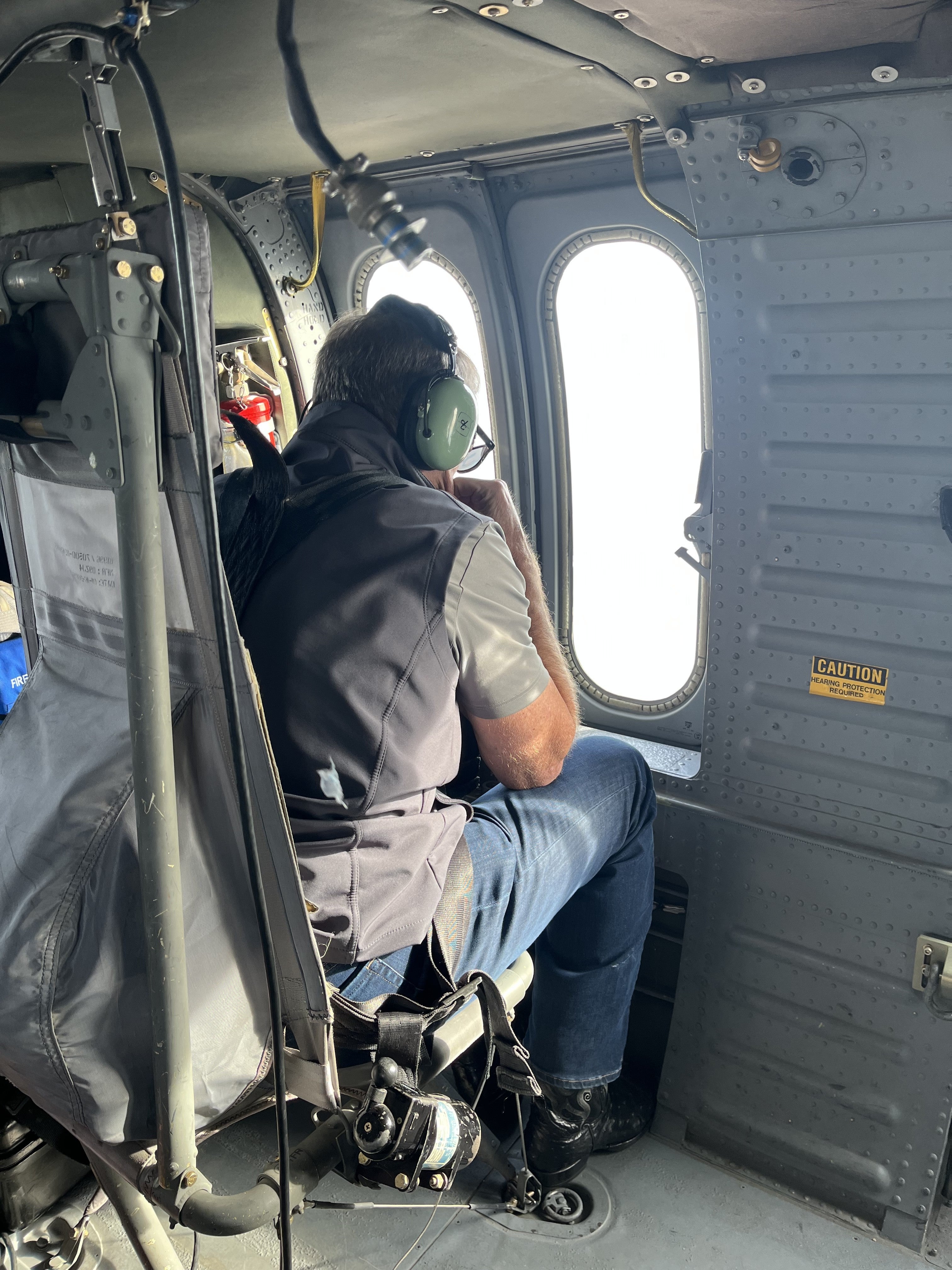 Governor Pillen looking out a window in a National Guard helicopter.