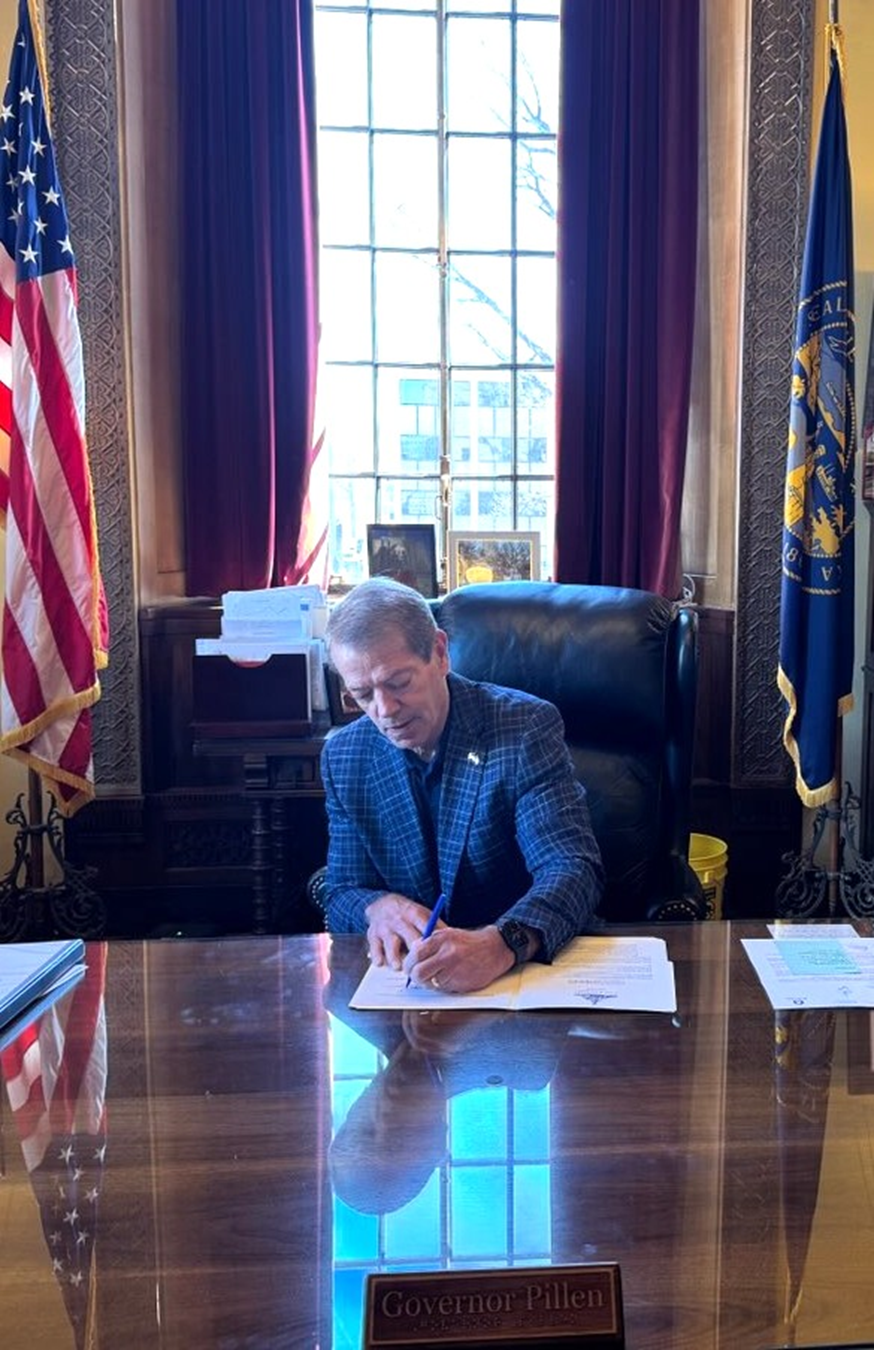 Governor Jim Pillen sitting behind his desk, signing an Executive Order to support fire relief for Ag Producers.